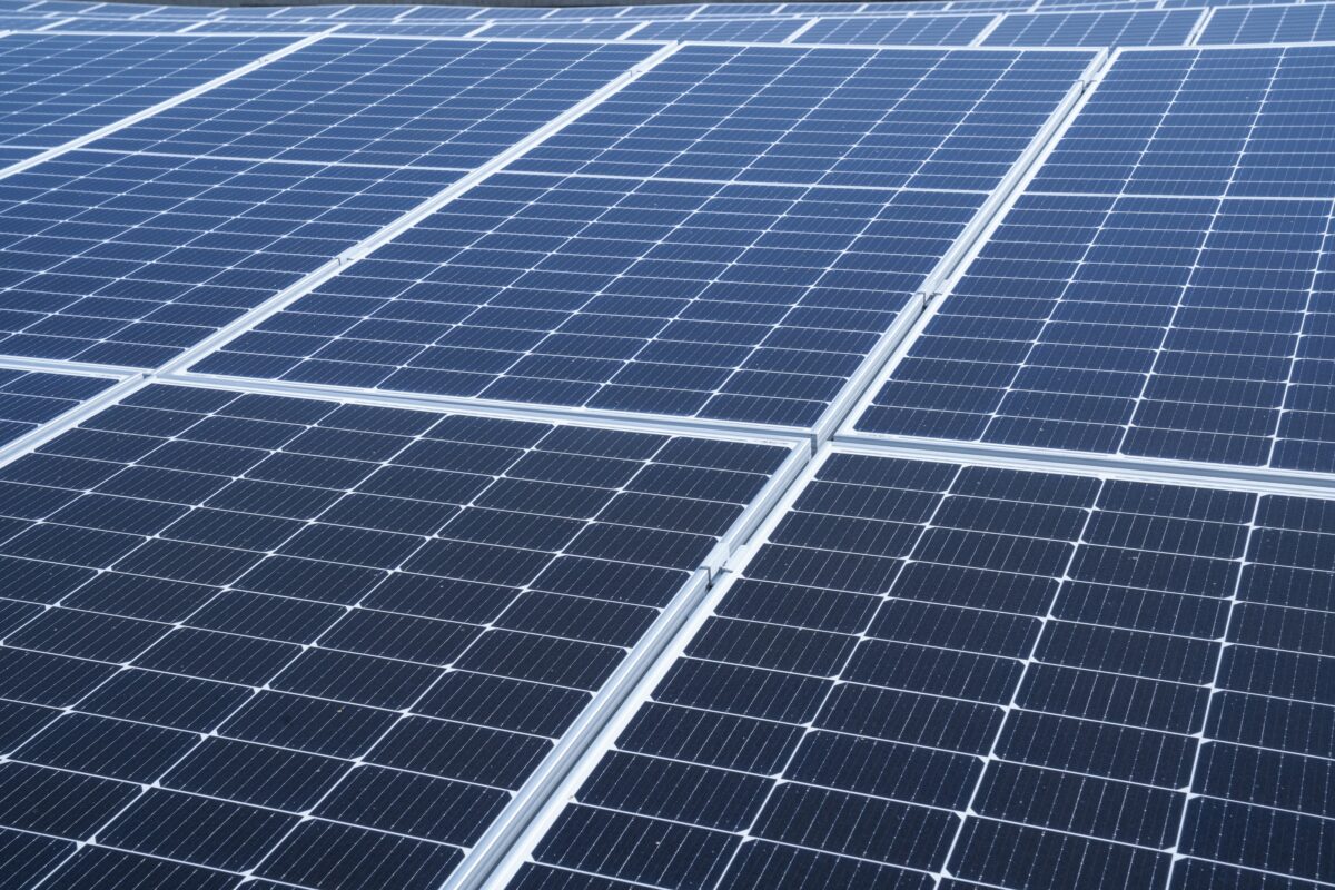Industrial battery storage units in a rural Basque setting with solar panels