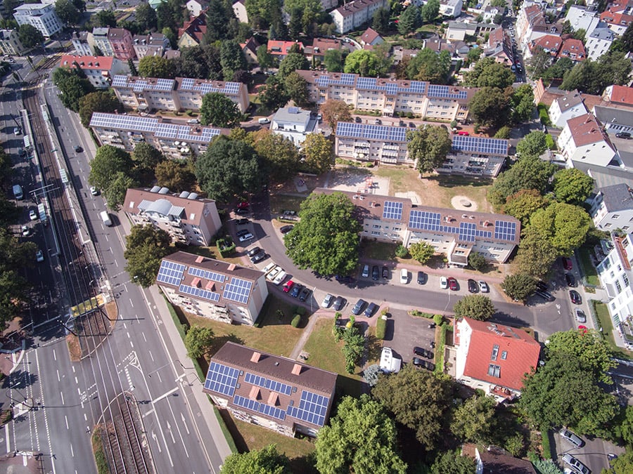 Rooftop solar panels on a commercial building in an urban German setting