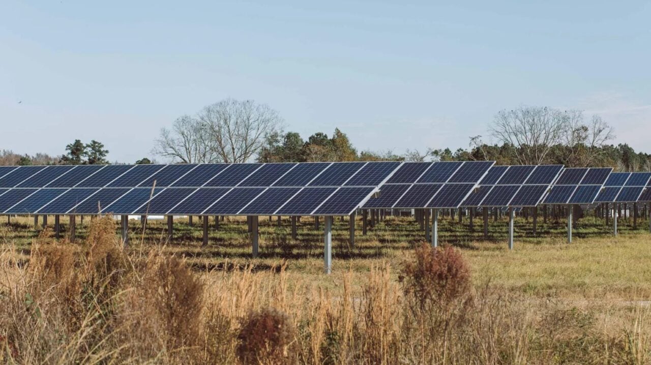 A massive solar array stretching across a rolling landscape formerly dominated by coal mining infrastructure.