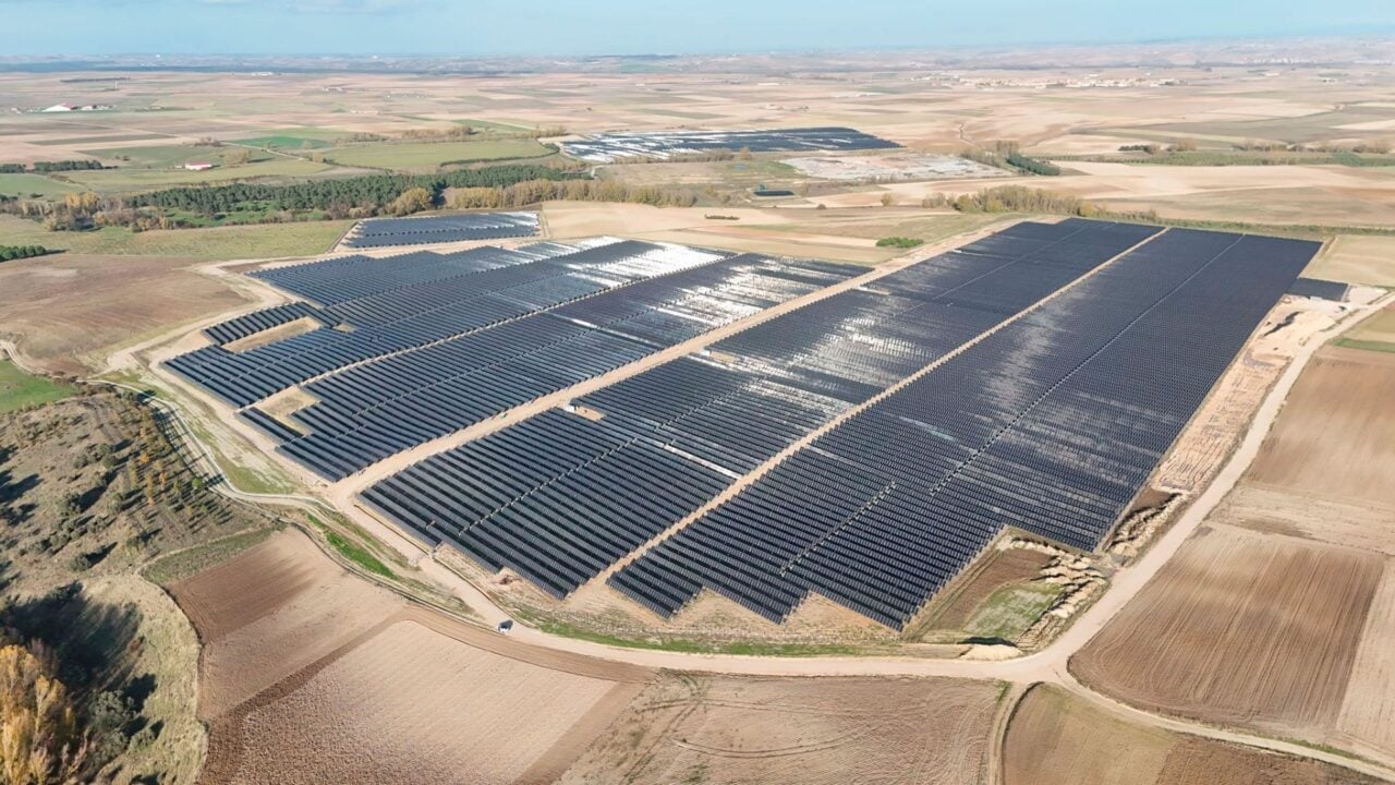 Aerial view of a Spanish utility-scale solar farm integrated with battery storage units near Seville.