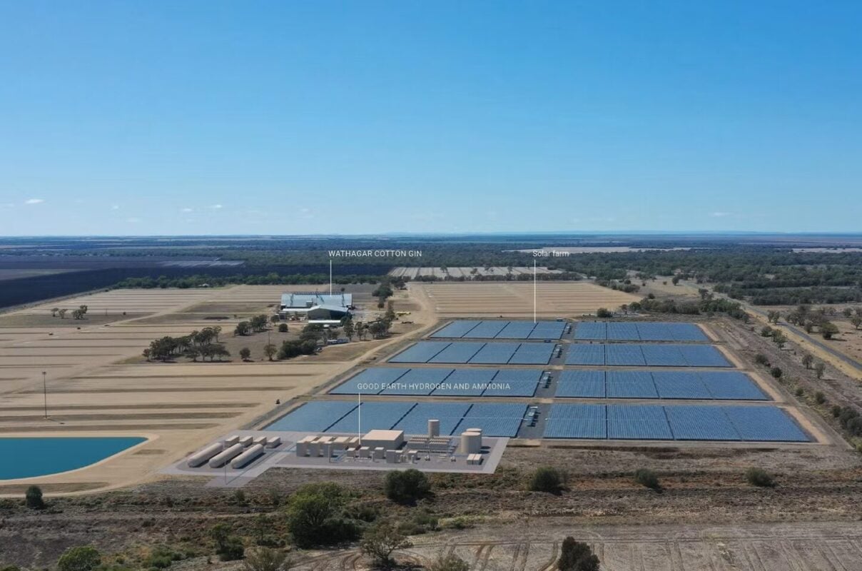 Aerial view of a large-scale solar farm integrated with hydrogen electrolyzer units and storage tanks.