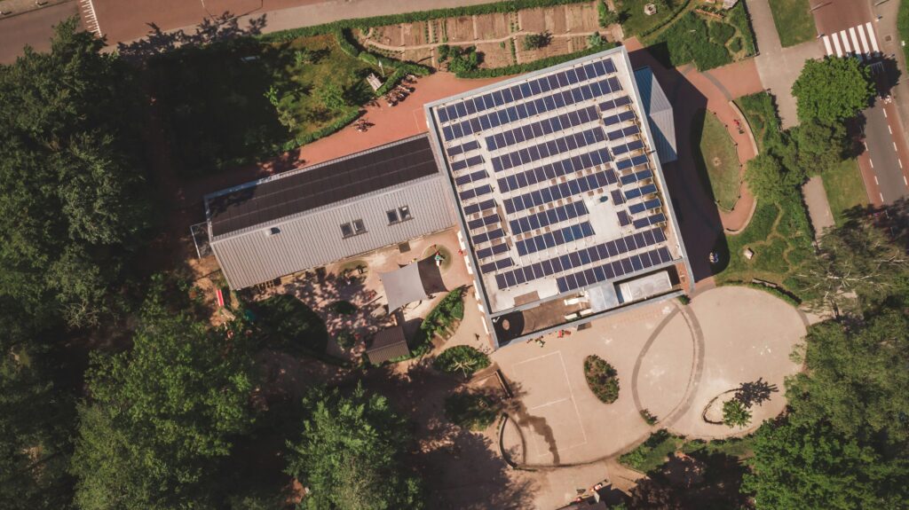 Aerial view of municipal buildings in a Spanish town with rooftops marked for solar panel installation.