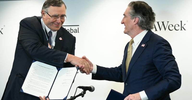 Offshore wind turbines standing in the ocean under a cloudy sky during sunset