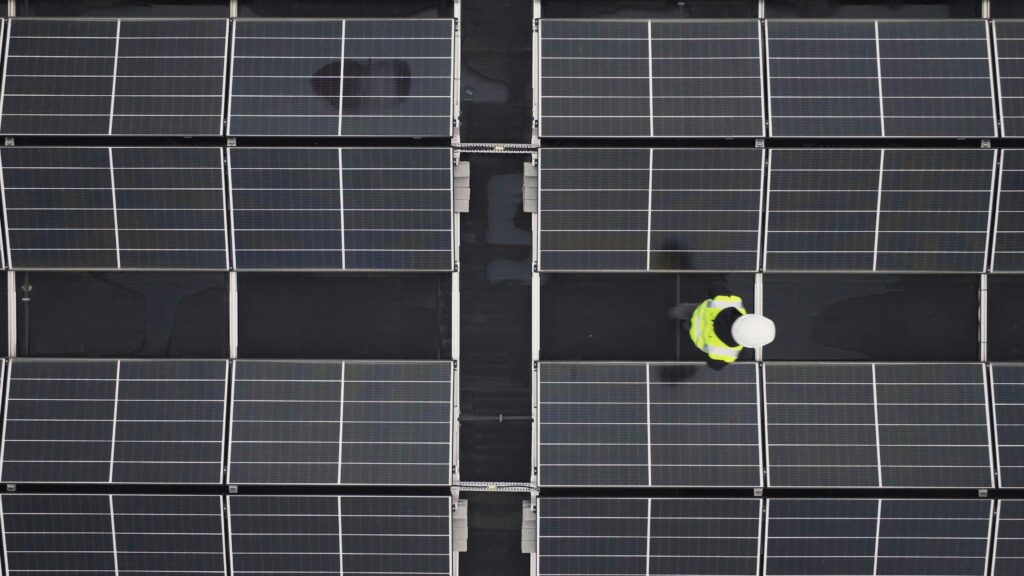 Aerial view of a municipal parking lot with a large solar panel canopy installation
