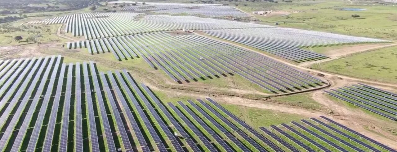 Large scale battery energy storage containers integrated with a solar PV farm in the Spanish countryside.