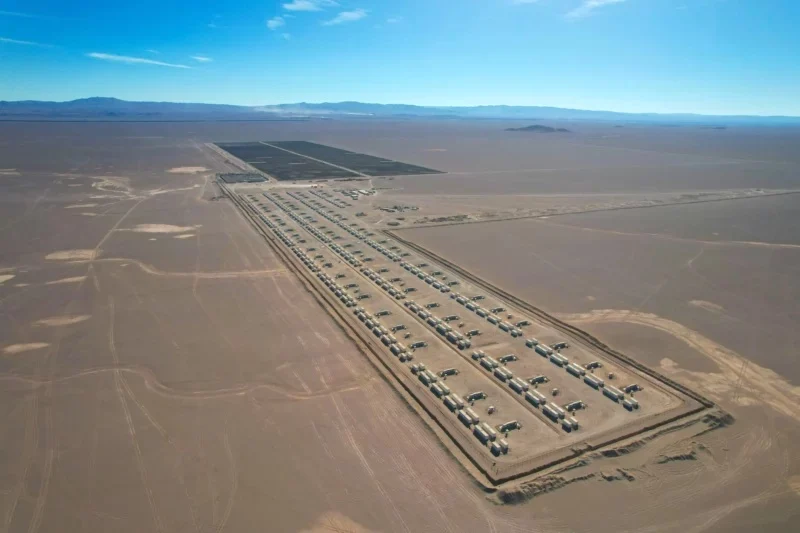Large scale battery energy storage containers arranged in rows in a desert landscape