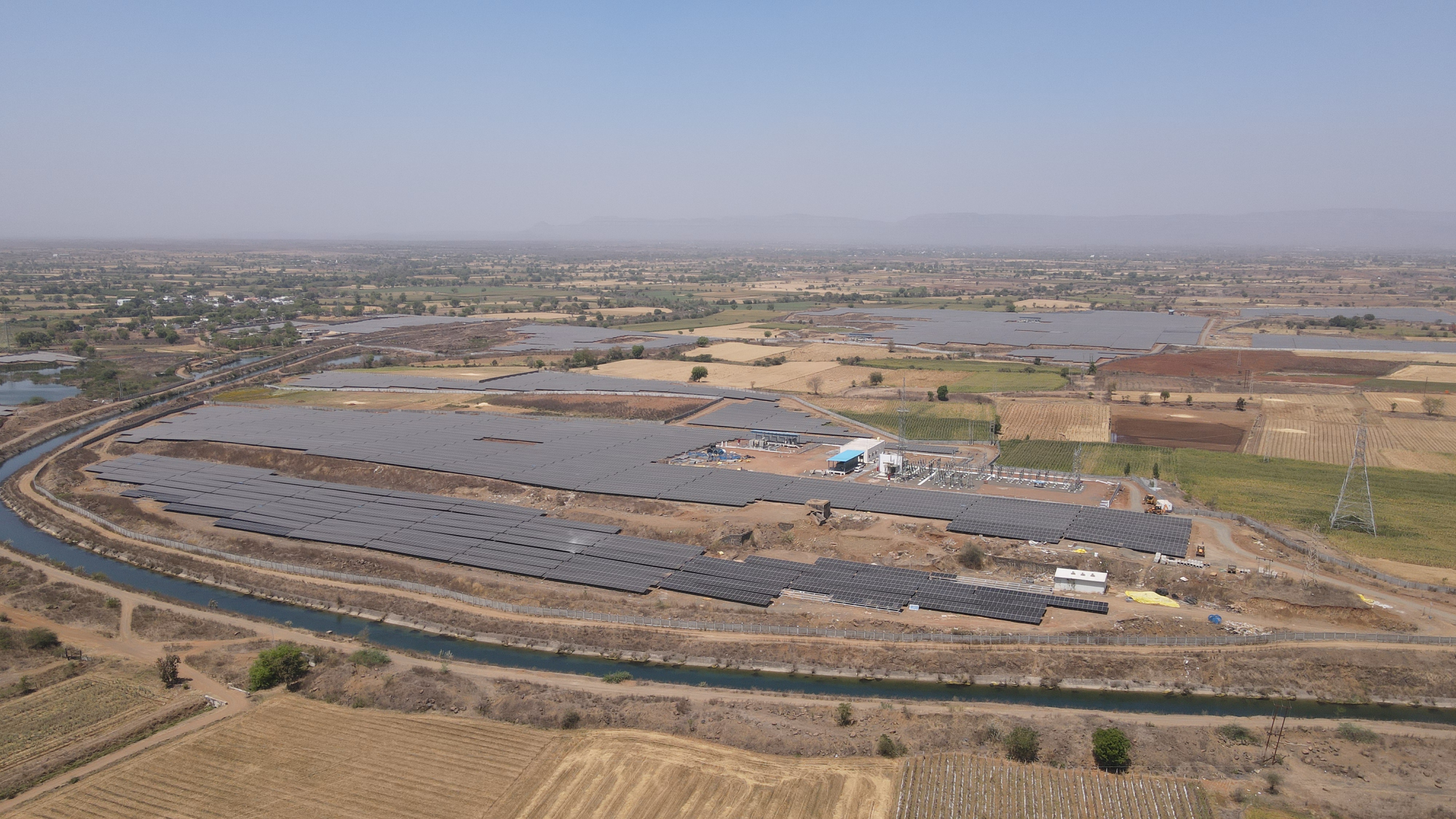 Aerial view of a large-scale solar farm layout in a dry landscape.