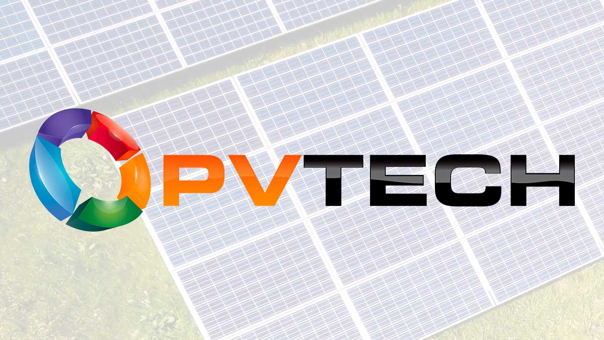 Close-up of an Enphase microinverter unit mounted behind a solar panel on a rooftop.