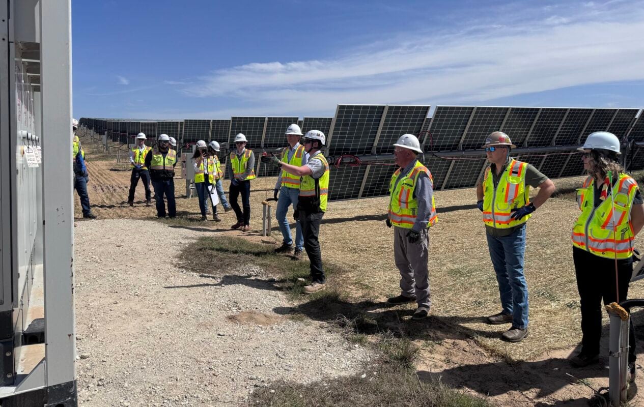Massive utility-scale solar array stretching across a flat Texas landscape under a clear sky.
