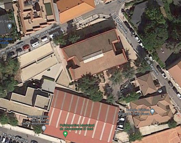 Rooftop solar installation on a Spanish school building with local residents nearby.