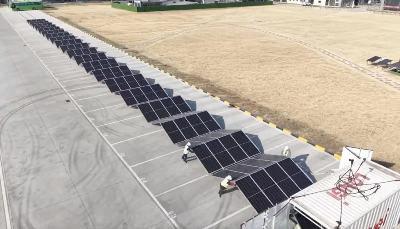 Large scale solar farm in Greece featuring LONGi bifacial modules under a clear blue sky.