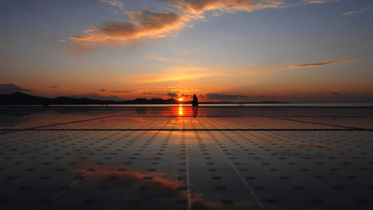 Massive utility-scale solar array spanning across the Saudi Arabian desert landscape under a clear sky.