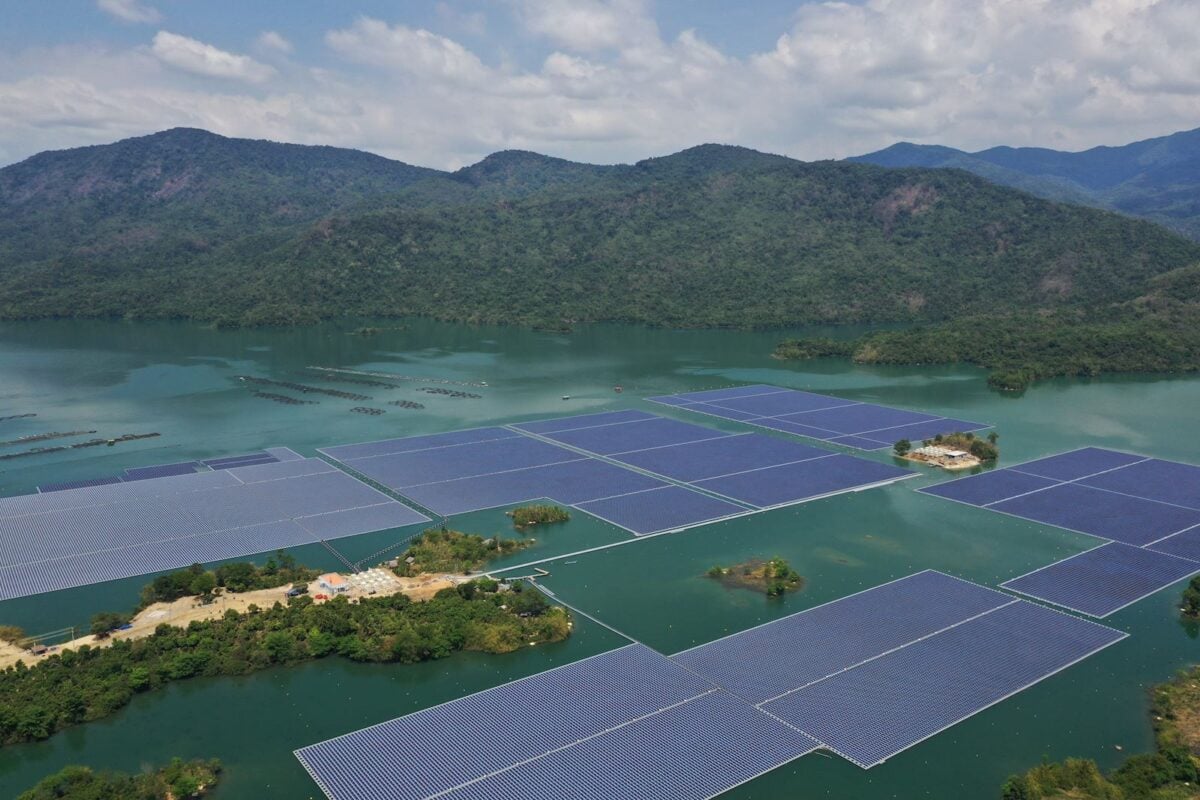 Large scale floating solar panels installed on a calm deep blue water reservoir surface