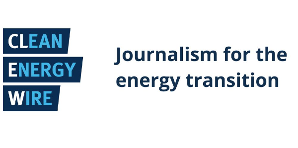 A journalist's notebook and laptop showing energy policy documents on a desk