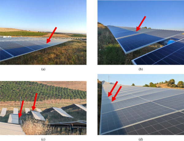 Aerial view of a solar farm with horizontal single-axis trackers installed on uneven, hilly terrain.
