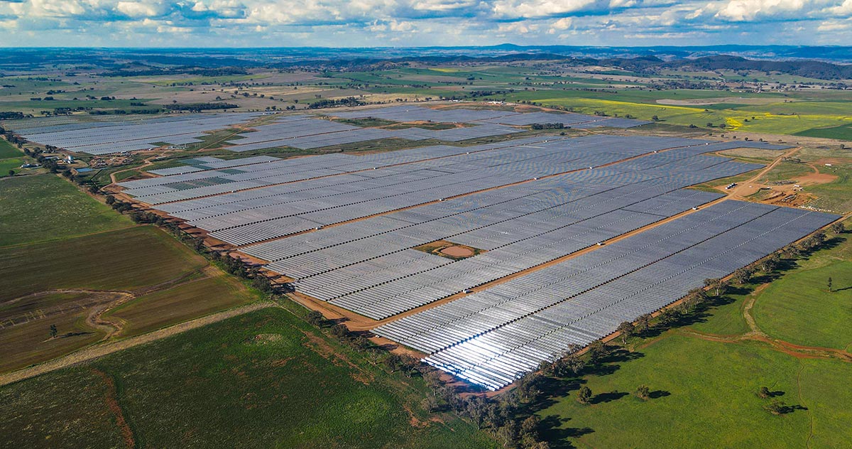 Aerial view of a massive utility-scale solar farm integrated with large-scale battery storage units