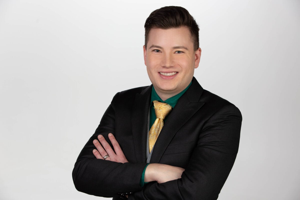 A technician inspecting a large-scale lithium-ion battery storage container on a sunny site