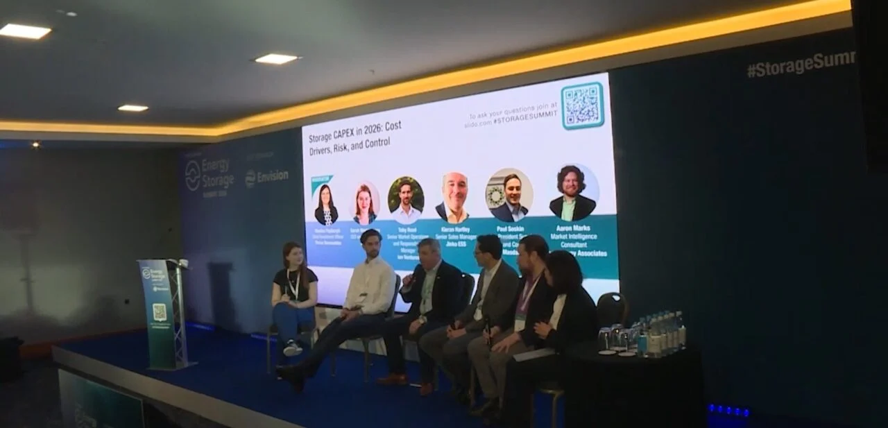 Technicians installing modular industrial battery storage units at a European solar farm site
