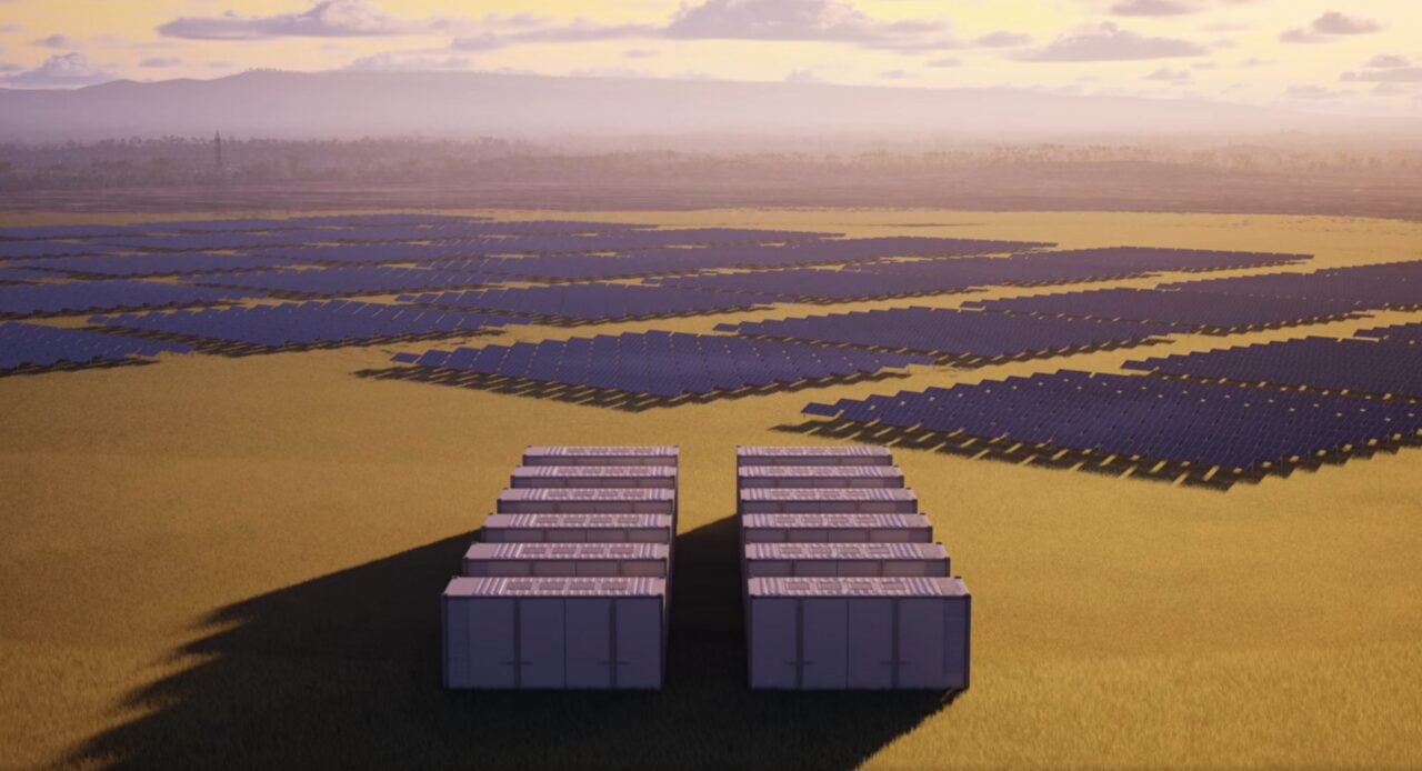 Large scale solar farm containers and lithium-ion battery storage units in a rural landscape.