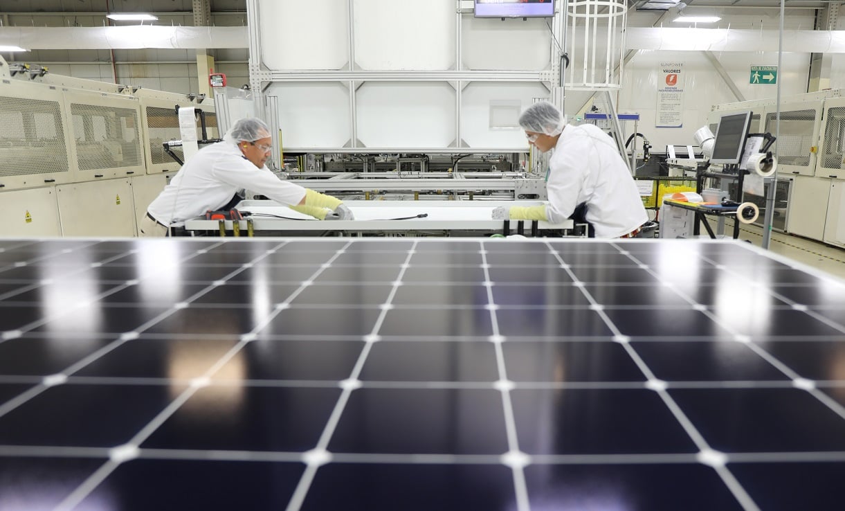 A high-efficiency solar panel with IBC technology reflecting a dark, stormy sky.