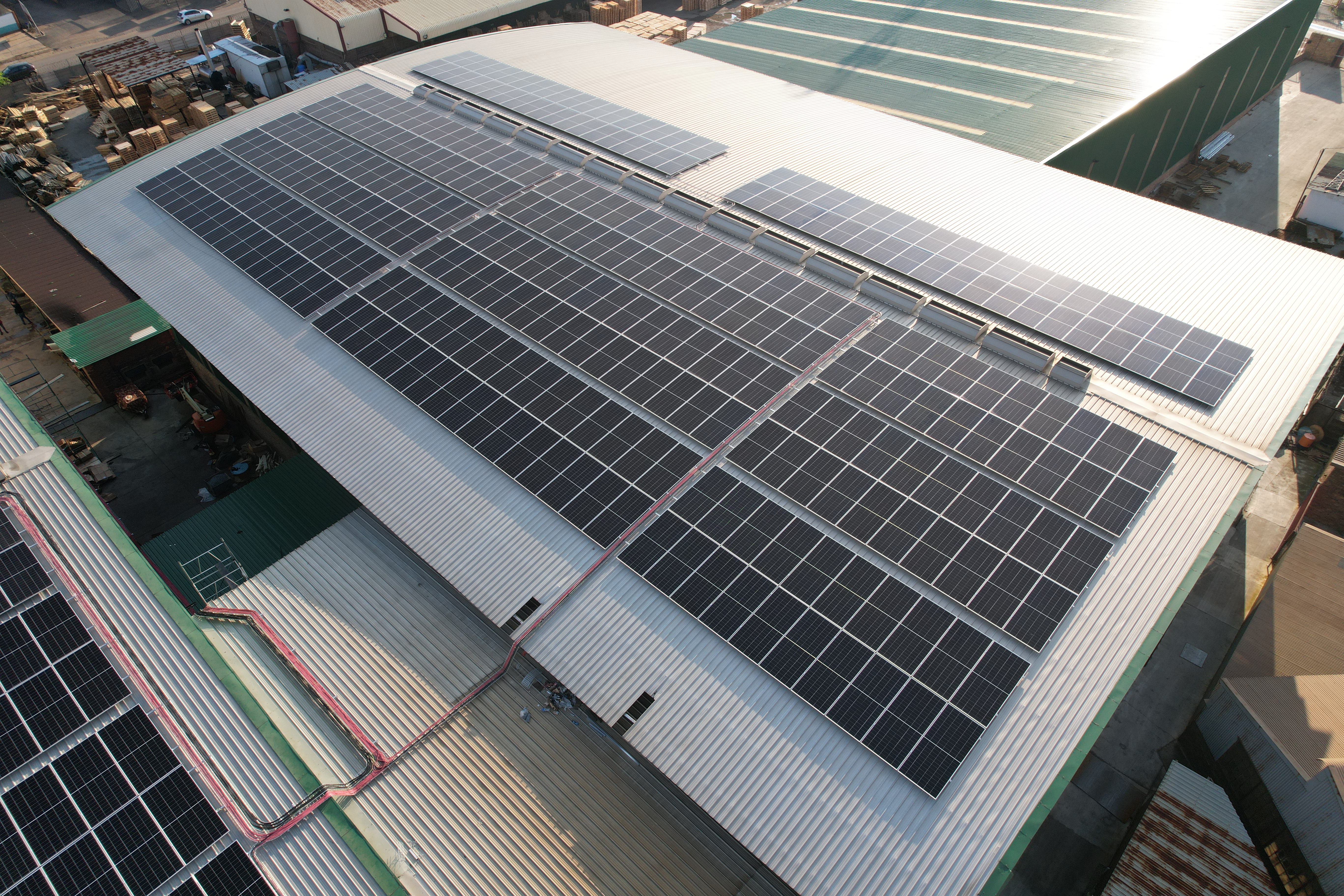 A large-scale commercial solar installation with hybrid inverters and battery storage units.