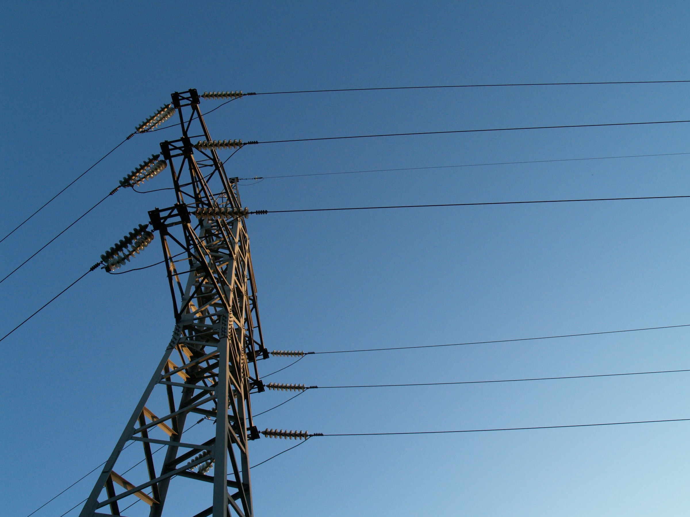 Large scale solar farm with high voltage power lines and a transformer station in the foreground.