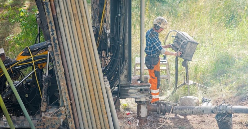 Construction site of a new-build residential development featuring integrated geothermal and solar energy infrastructure.
