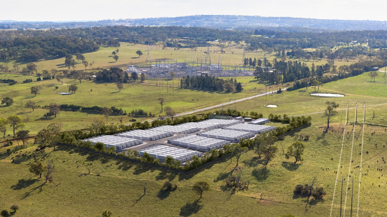 Aerial view of a large-scale lithium-ion battery energy storage system facility with white enclosures