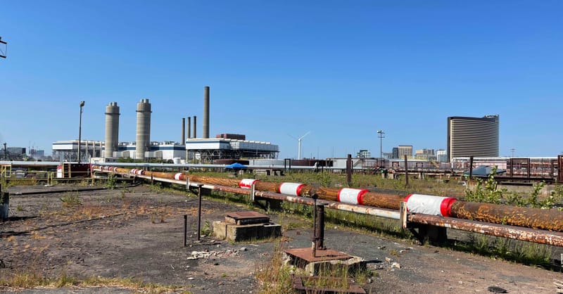 A modern residential home with rooftop solar panels and a wall-mounted battery storage unit