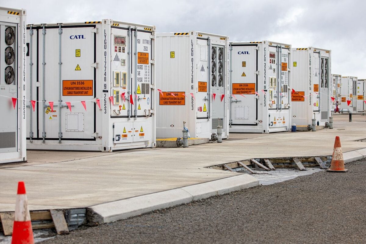 Aerial view of a massive utility-scale battery energy storage system in the Australian outback during sunset.