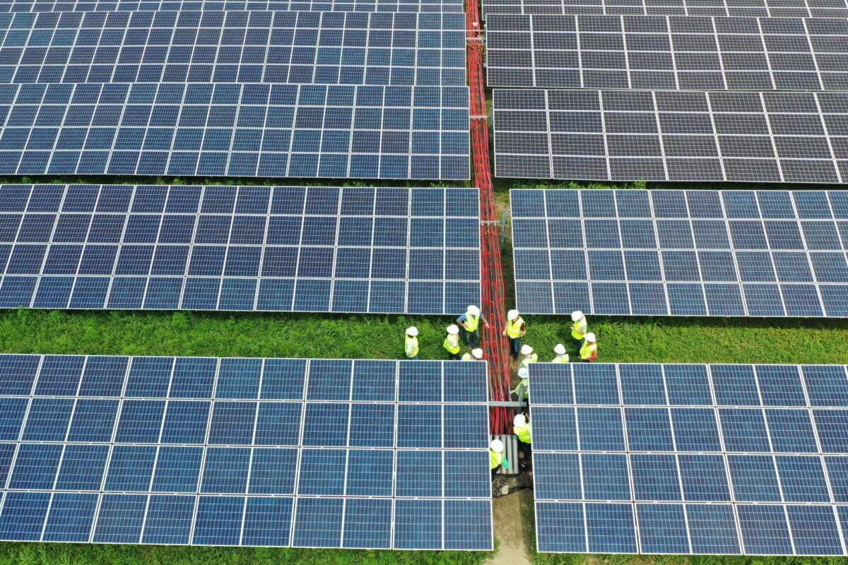 A community solar array in a rural US field with nearby residential housing