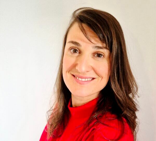 A rows of solar panels in a French field with a power grid substation nearby.