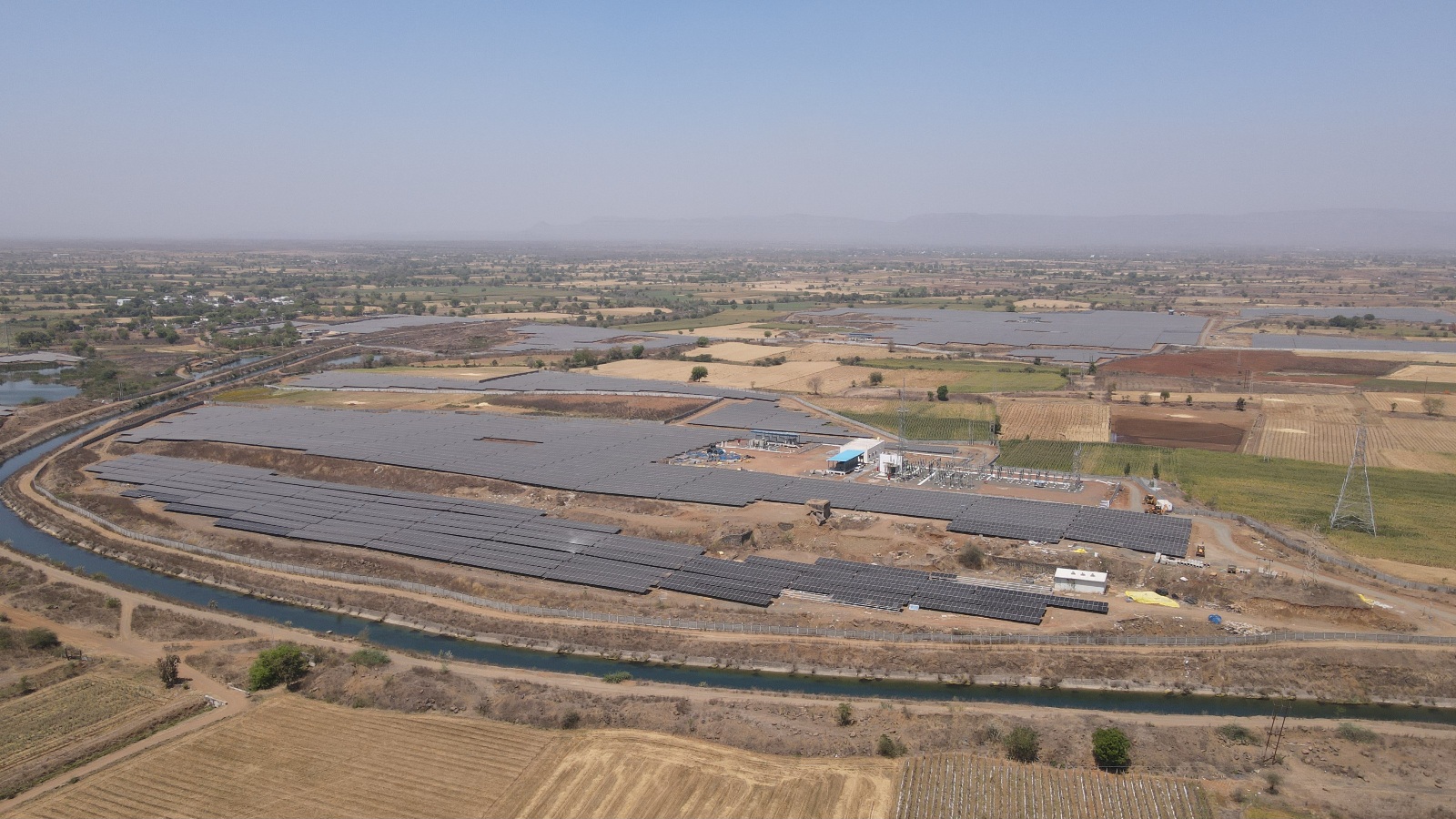 Aerial view of a large-scale solar farm layout in a sunny region