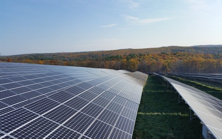 Aerial view of a solar farm integrated with agricultural sheep grazing on green pastures