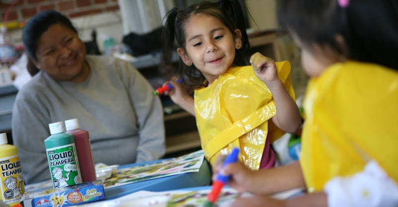 A technician installing a modern air-source heat pump next to a solar-powered residential home.