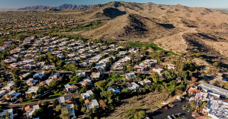 A digital thermostat display on a wall next to a modern smart home energy monitor.