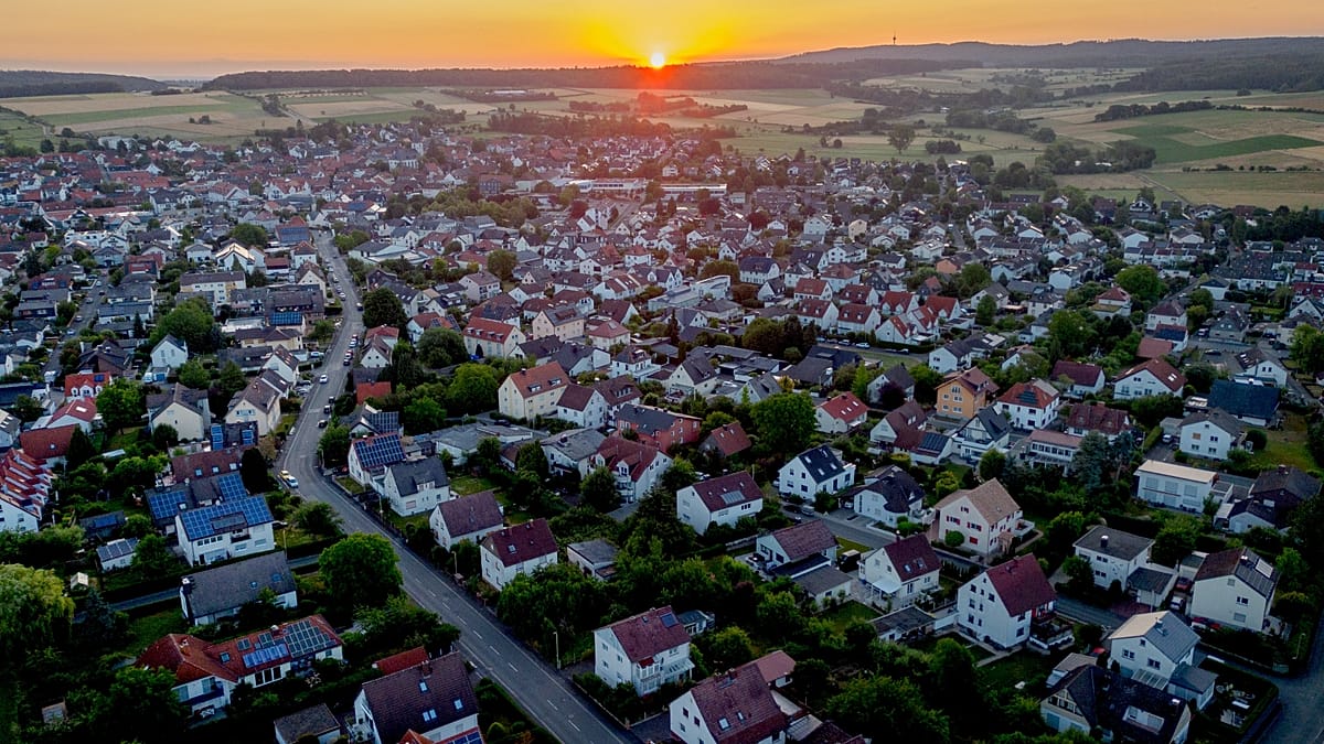 Aerial view of a German village with wind turbines and solar panel installations nearby