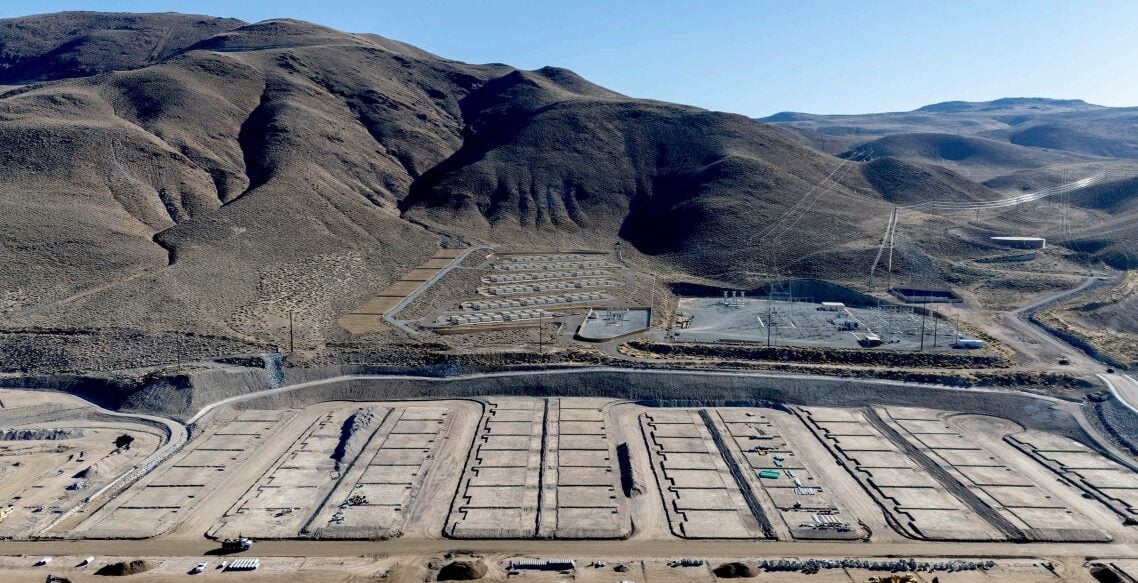 A large-scale grid-connected battery energy storage system facility with rows of shipping-container-sized battery units.
