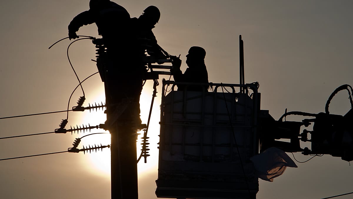 High-voltage power lines against a sunset, symbolizing European grid infrastructure upgrades and permitting reform.