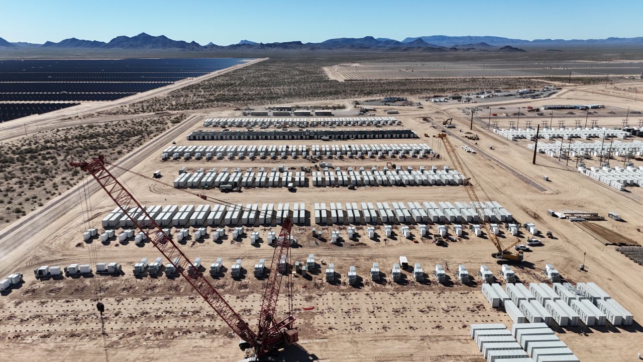 Large scale solar farm in a desert landscape with rows of PV panels stretching to the horizon