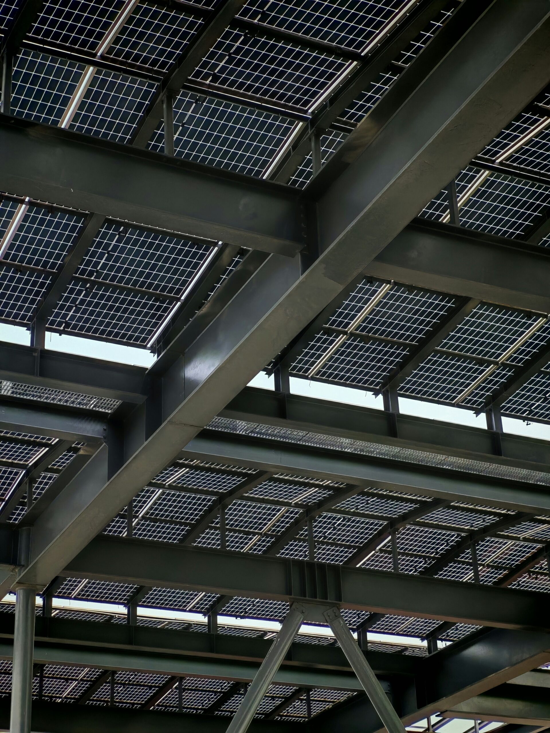 A solar carport installation on a rugged, sun-drenched volcanic island coastline with EV charging stations.