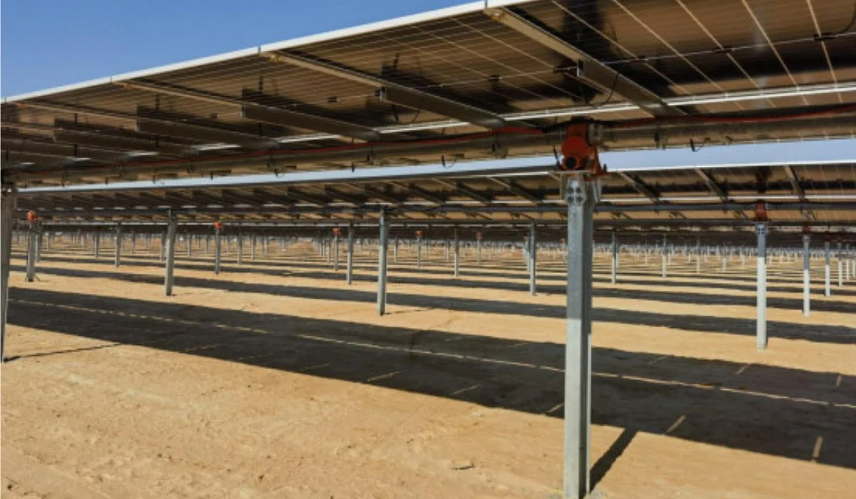Large scale solar tracker system with robotic cleaning attachment on display at a clean energy trade show.
