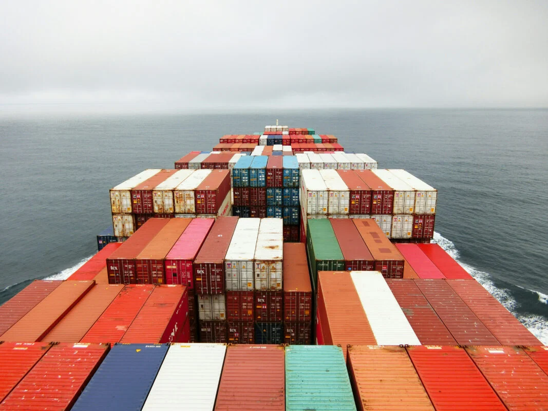 A row of solar modules stacked in a shipping container at a port terminal.