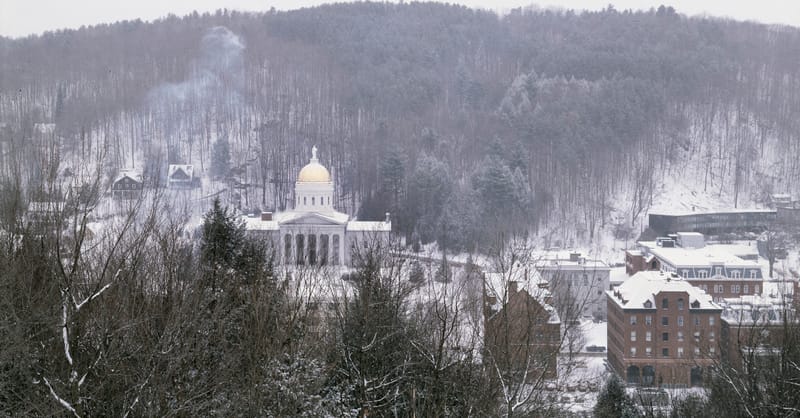 A residential heat pump unit installed next to a solar inverter on a brick wall