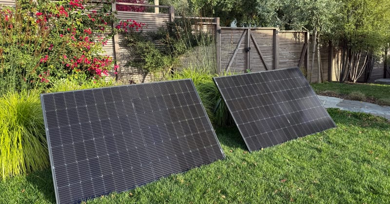 A modern apartment balcony featuring a compact, plug-in solar panel kit installed on the railing.