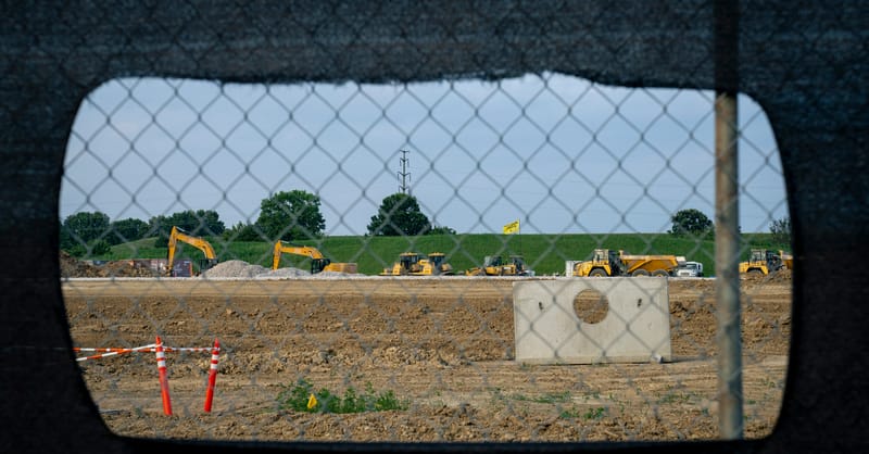 A modern solar farm installed next to a large industrial data center facility.