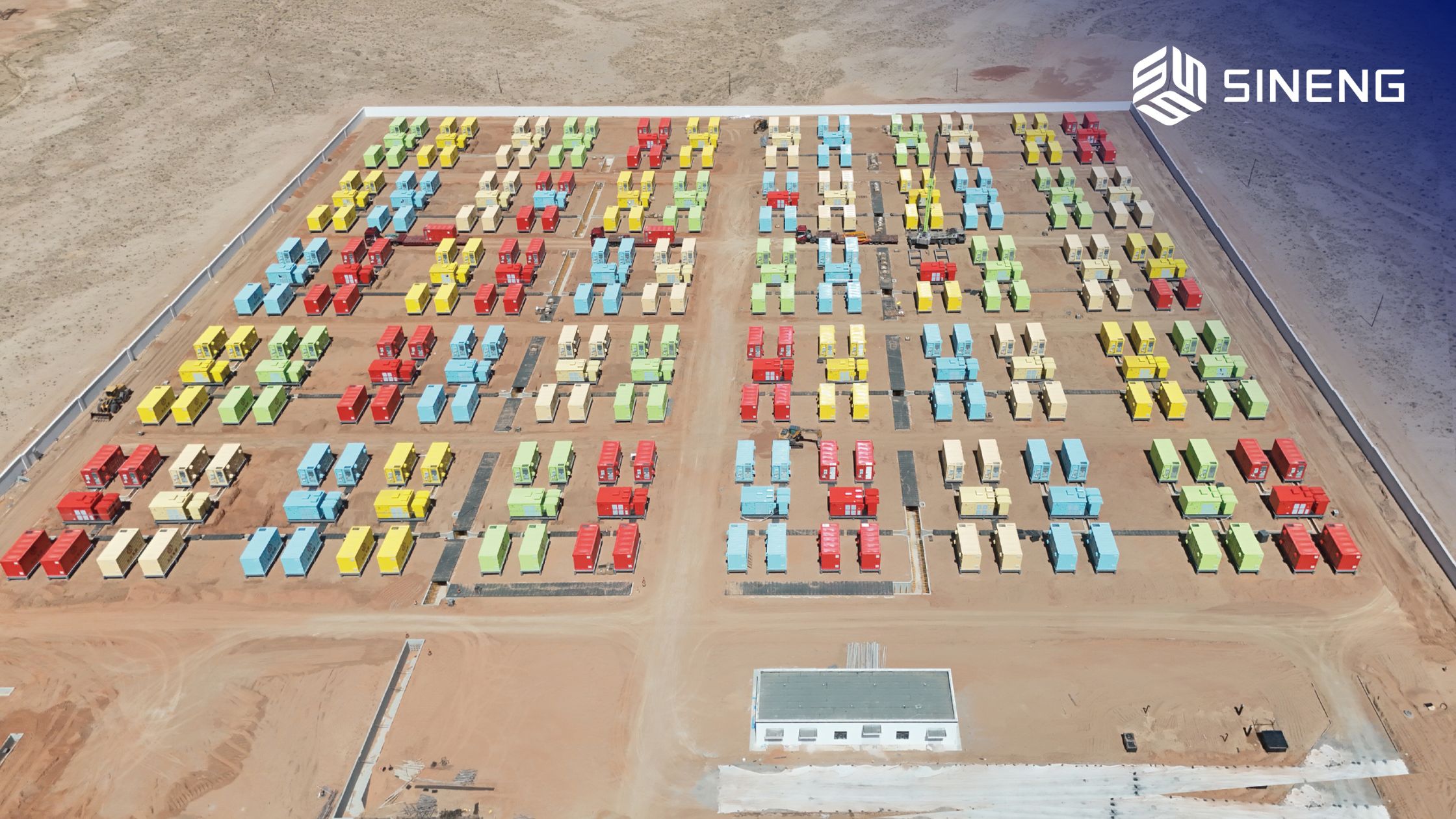 A massive, utility-scale battery energy storage system facility under bright daylight.