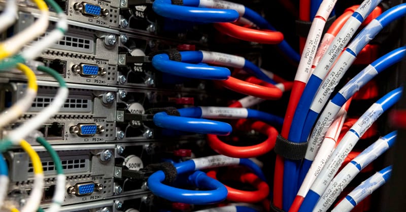 A technician inspecting commercial solar panels on a large industrial rooftop facility during sunset.