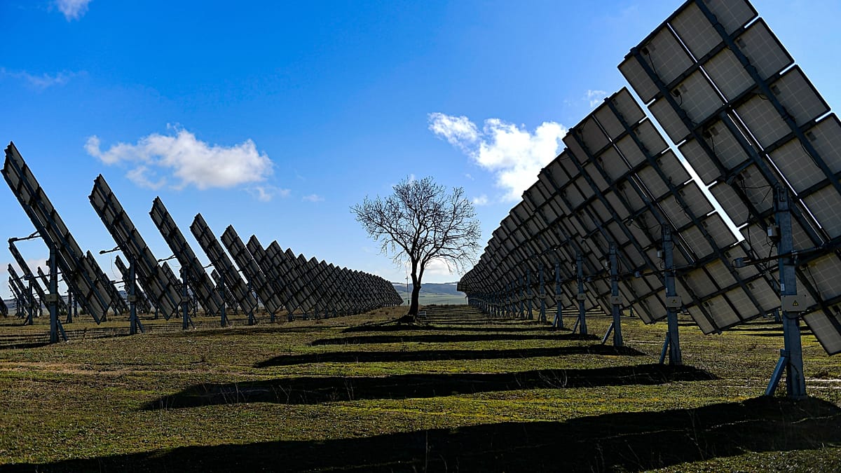 A vast field of solar photovoltaic panels under a bright Spanish sun in rural landscape.