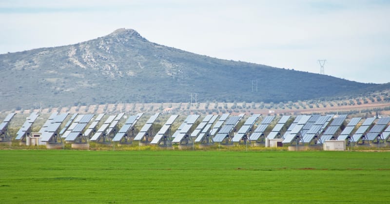 A row of modern residential solar panels installed on a European rooftop at sunset